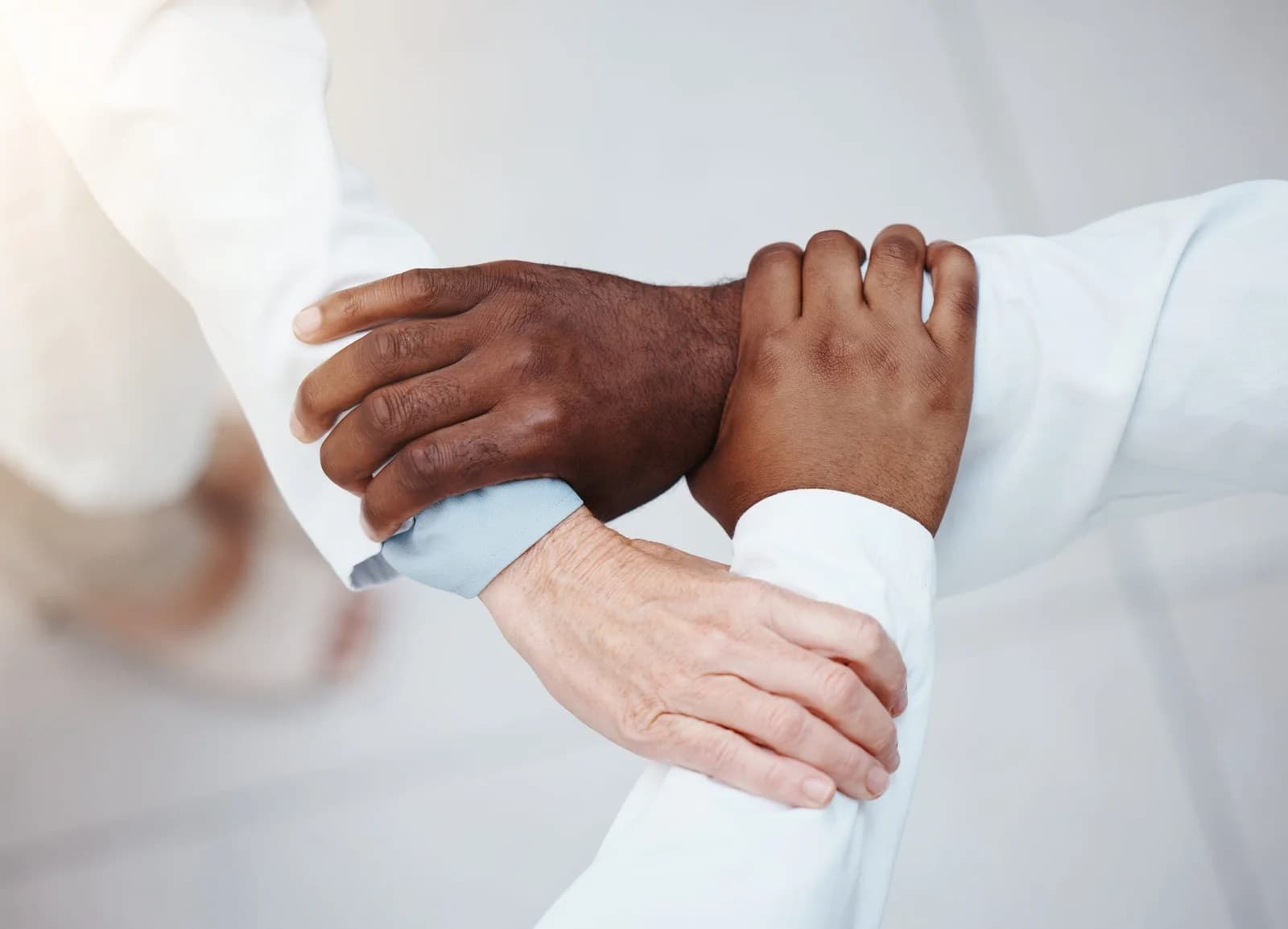 Hands joined over a table during a partnership meeting.