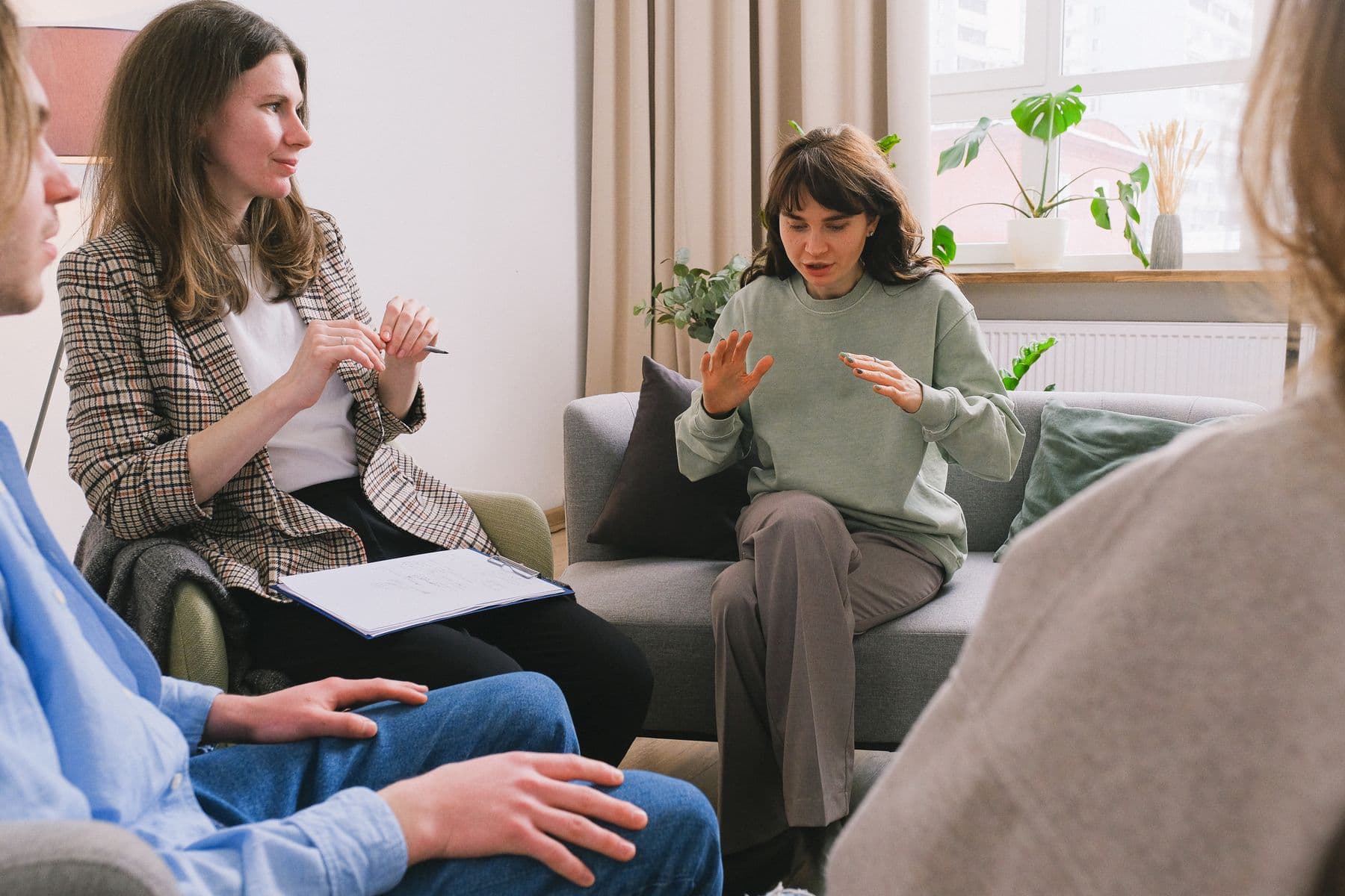 A support group sharing together in a warm, light-filled room.