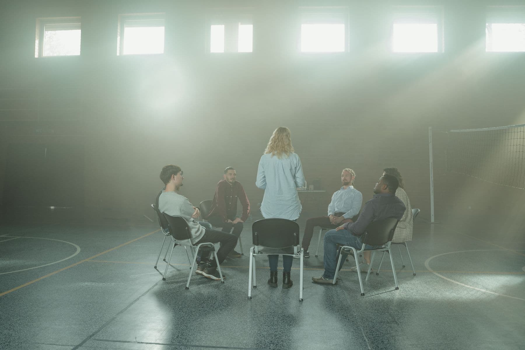 A recovery support circle meeting together in a bright hall.